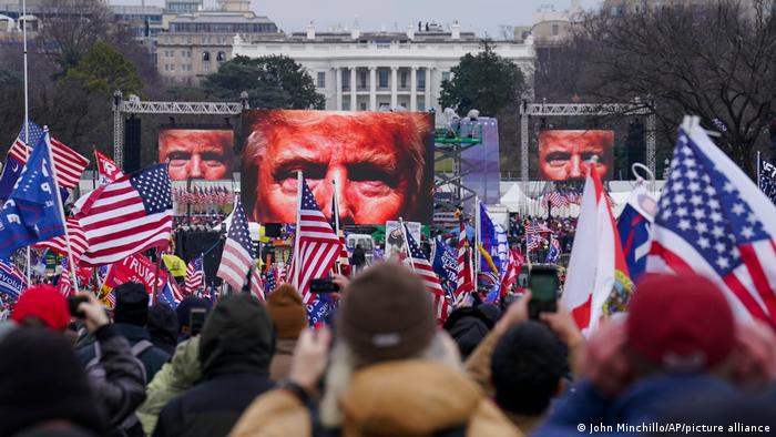 Trump on video screens in front of white house